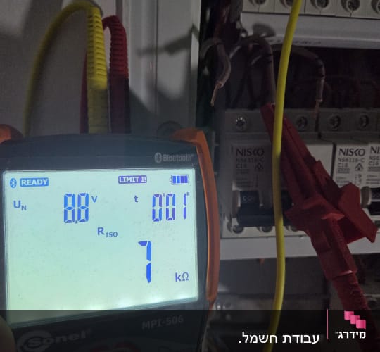 מד מתח חשמלי ליד לוח חשמל פתוח